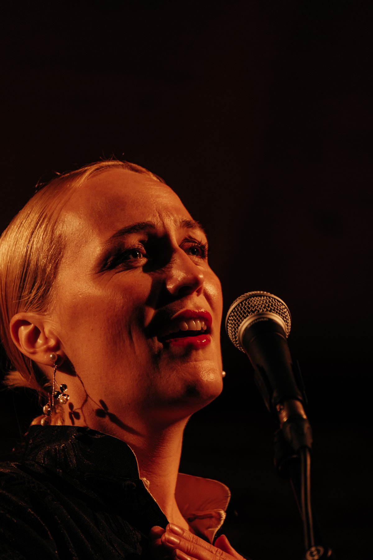 Närbild på artist i varmt rödljus under en konsertkväll på Lilla Björkö