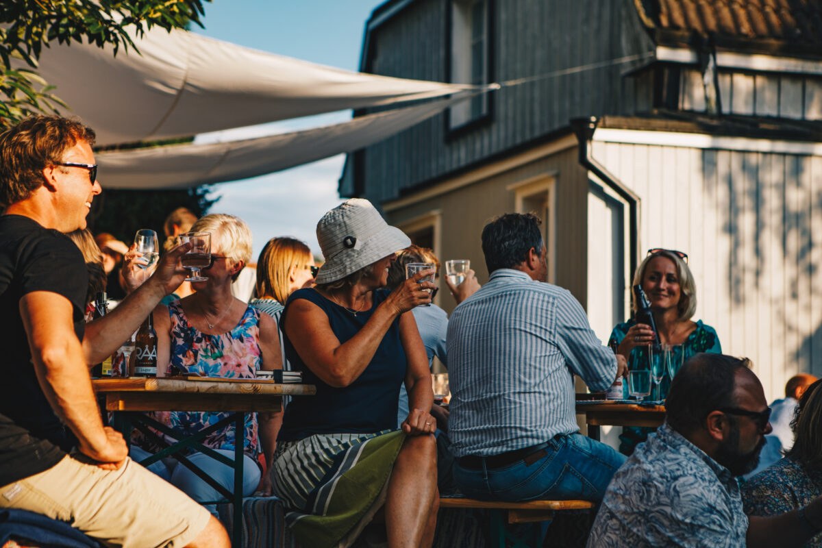 Gäster som umgås runt trädgårdens bord, 2019